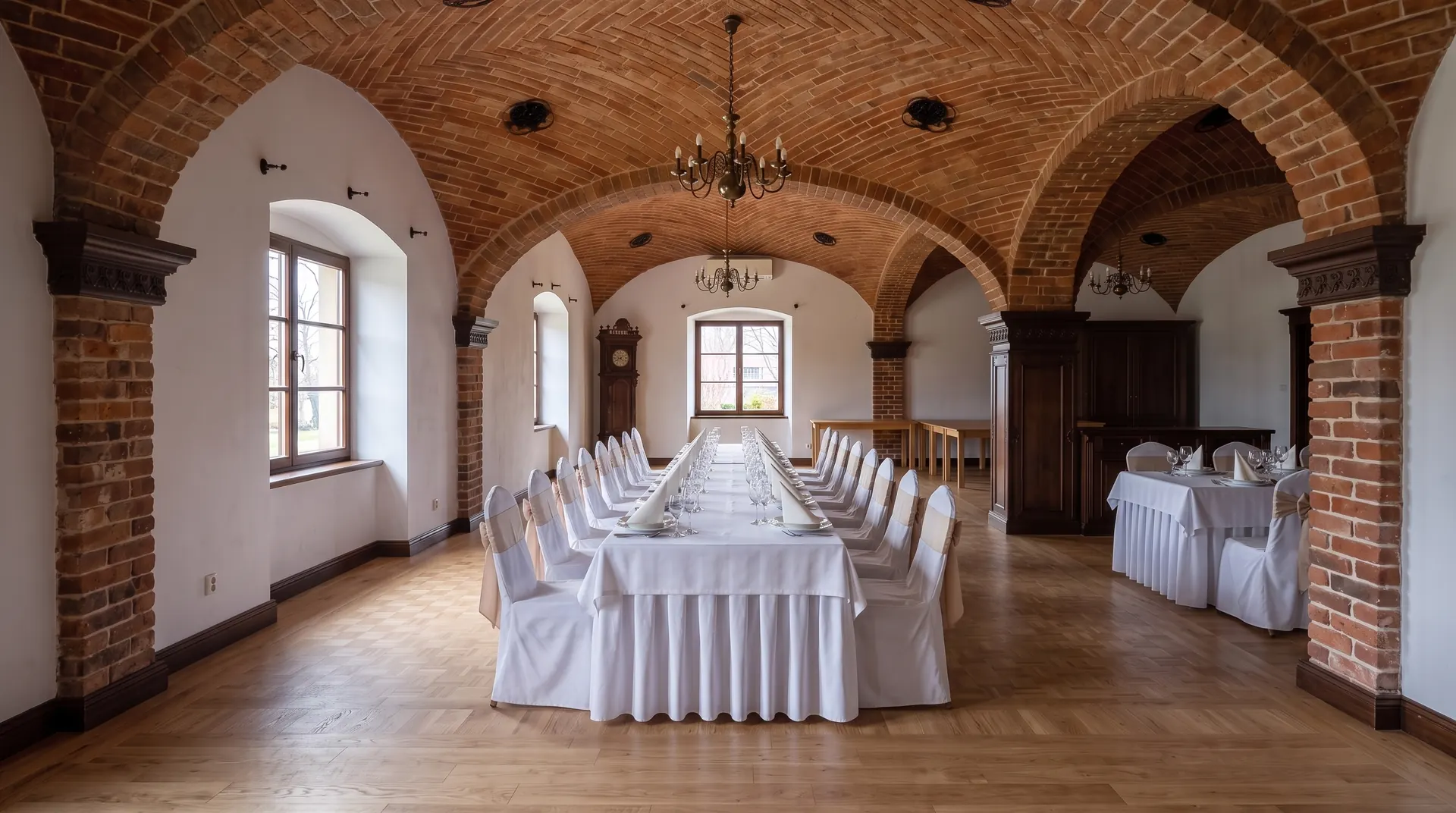 Ta sama sala z nakrytymi stołami i pokrowcami na krzesłach